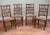 Attractive set of four country dining chairs with tall spindle backs and woven rush seats. Shaped crest rails with rounded...