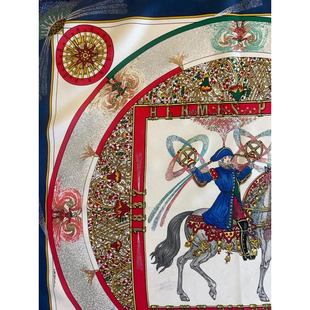 Hermès Feux d'Artifice 1999 Duchene Michel Gavroche silk scarf with a black background depicting a rider dressed in red. A...