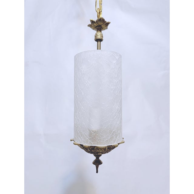 This lantern has a brass frame with a frosted cylinder glass shade. It has 4 lights that each use a 60W candelabra base...