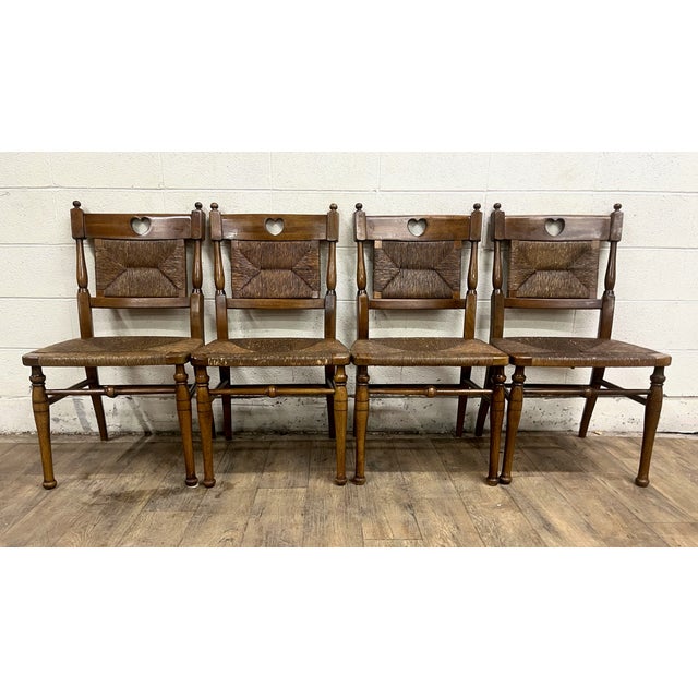 This is a set of four vintage Hitchcock rush seat and rush back dining side chairs with unique heart cutout handles. They...