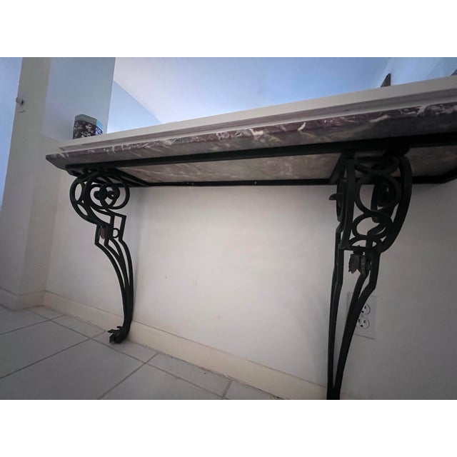 An elegant, space-saving wall-mounted console table featuring a substantial, hand-polished Rosso Levanto marble top. The...