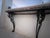 An elegant, space-saving wall-mounted console table featuring a substantial, hand-polished Rosso Levanto marble top. The...