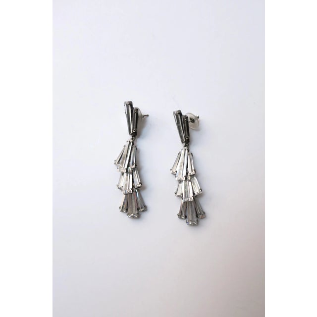 A gorgeous pair of diamond-like crystal dangle earrings by Jarin. Beautiful baguette cut crystals set in rhodium plate...