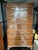 Traditional Colonial Revival Chippendale-style mahogany-finish highboy/chest-on-chest featuring a molded cornice, carved...