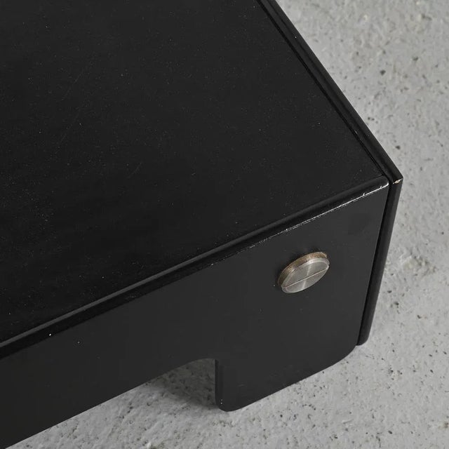 We like the elegance of this black lacquered plywood table, decorated with wide stainless steel screws designed by famous...