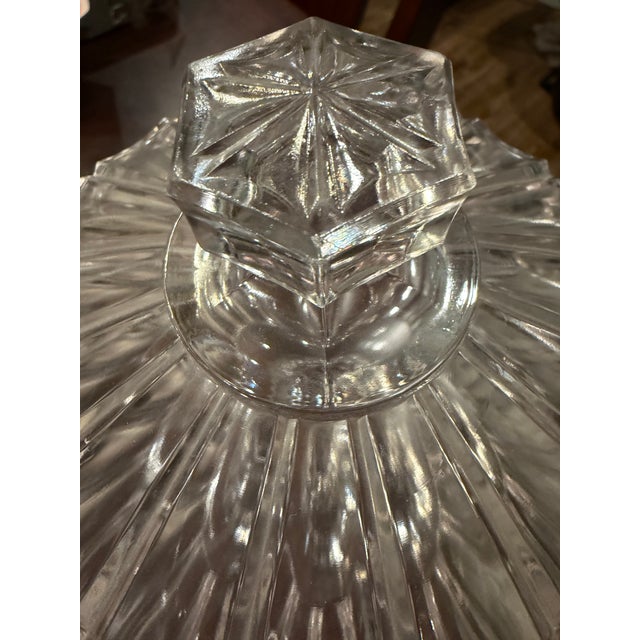 Description: An antique clear pressed glass covered compote in Doyle & Co.’s No. 400 Banded Prism Bar pattern. Introduced...