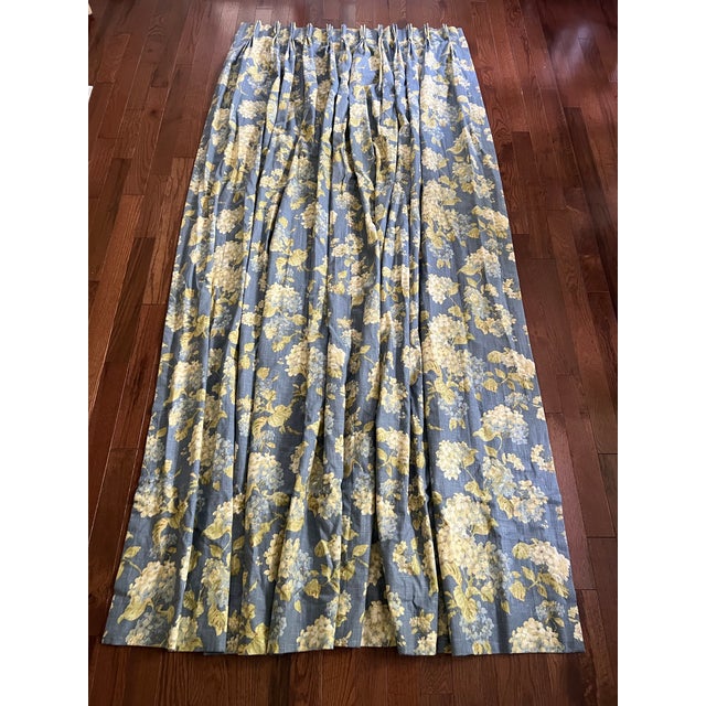 Pair of Waverly pinch pleated and lined custom curtains in floral Rolling Meadows pattern featuring white and blue...