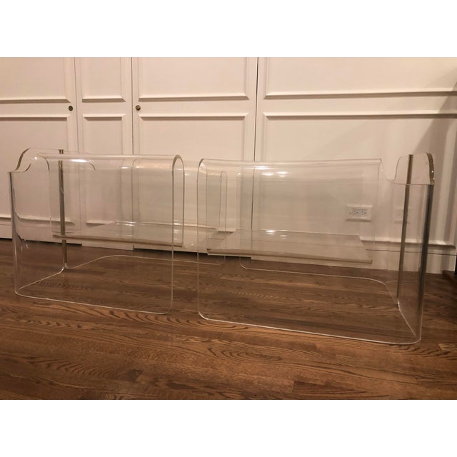 A pair of amazing vintage acrylic lounge chairs with a brass stripe in the back. Toss with an assortment of pillows in a...