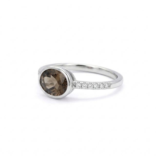 This elegant ring features a captivating Smoky Quartz gemstone, admired for its rich earthy-brown tones and subtle,...