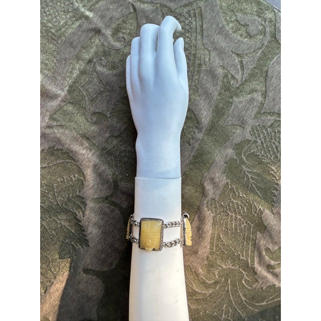 A circa 1950s Mexican silver link and chain bracelet with carved tribal mask agate stones.