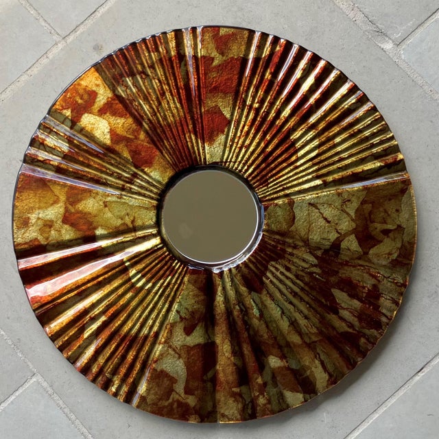 Excellent Pre-Owned Condition. Colorfully dramatic verre eglomisé-style reverse painted “sunburst”-shape wall mirror...