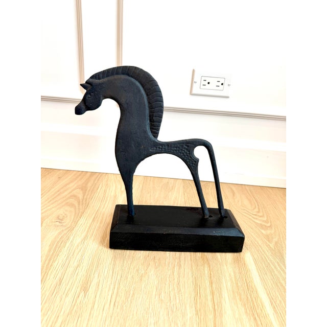 A striking mid-century cast iron horse sculpture inspired by the stylized equine forms found in ancient Etruscan and...