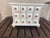 This tabletop apothecary chest features 12 square mini-drawers arranged in a 3x4 grid. The piece is constructed from wood...