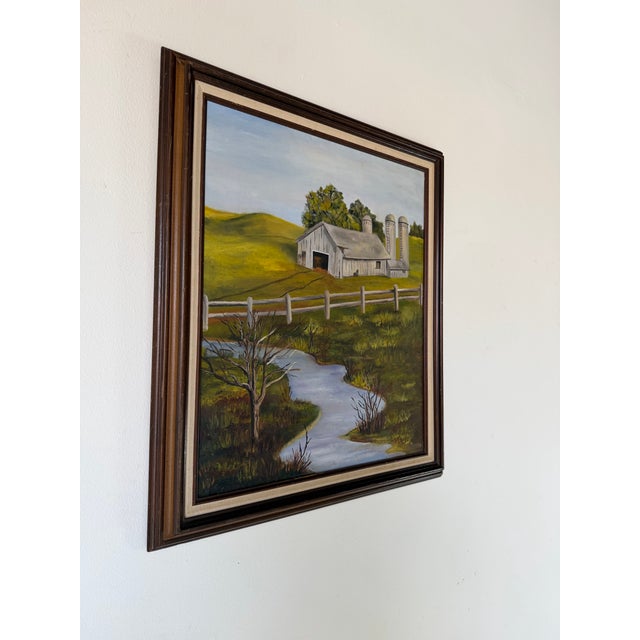 A charming 1970s vintage oil on canvas depicting a peaceful rural farm landscape with a winding river, rolling green...