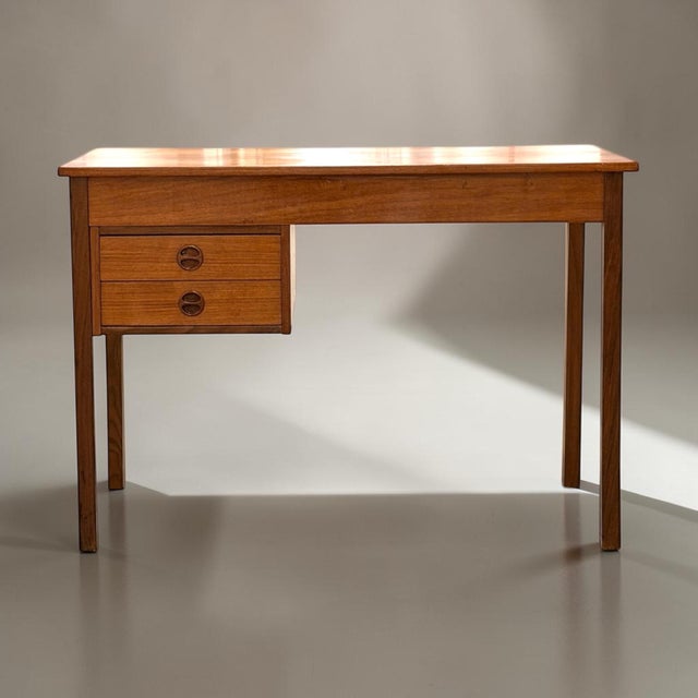 Compact danish writing desk executed in teak and produced in denmark during the 1950s. the desk reflects the restrained...