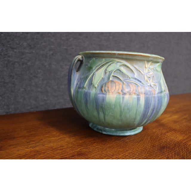 Roseville Pottery Baneda jardiniere featuring a rounded form with applied handles and raised botanical decoration. The...
