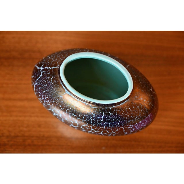 A striking german vase from the 1960s… its coppery sheen with iridescent purple and gold reflections captures the light...