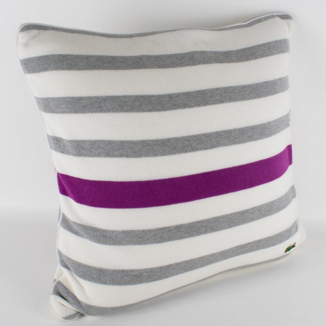 This stunning throw pillow was designed by Lacoste Paris. This lumbar pillow is covered in knitted fabric with a tennis...