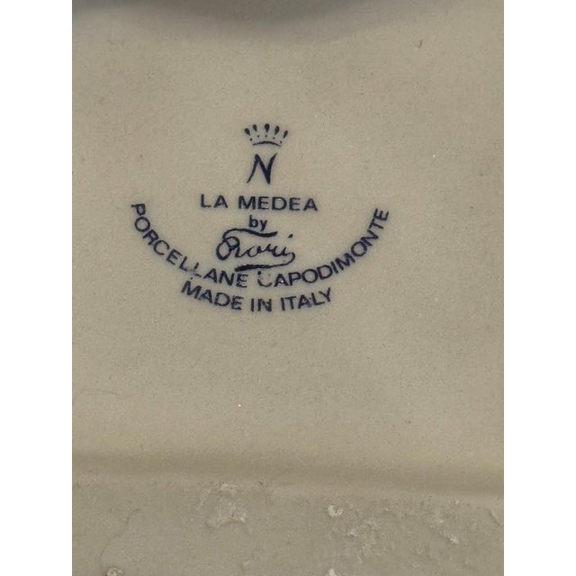 Hand-painted glazed porcelain group by the La Medea workshop of Naples, sculpted by Rori: an apothecary behind a marble-...