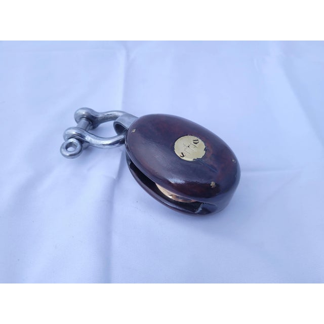 Nautical pulley block by Merriman from the early twentieth century. Brass badges with trident symbols. This relic has been...