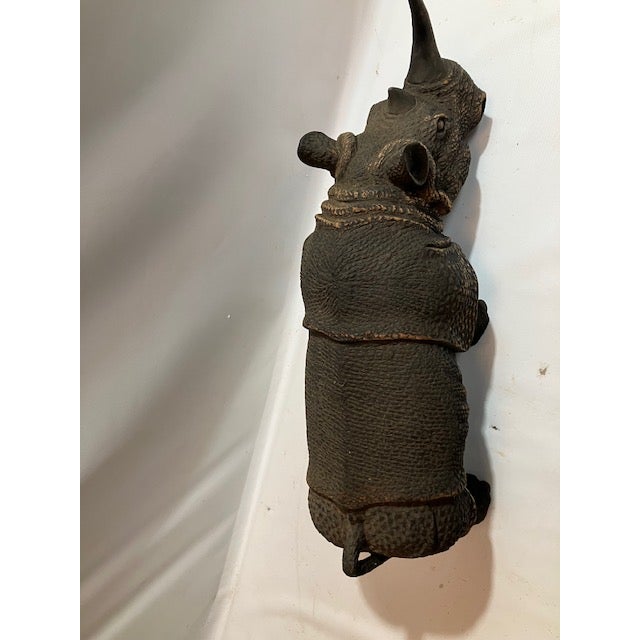 Our noble rhino sculpture shows off the details of the largest safari animal. He is poised with a lowered head in a...