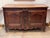 18th century French walnut buffet with a plank top and canted front corners. The frieze is carved with bands of...