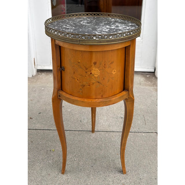 Antique French Marble Top Satinwood Inlaid Side Table. It features a rolling door that reveals hidden drawers.