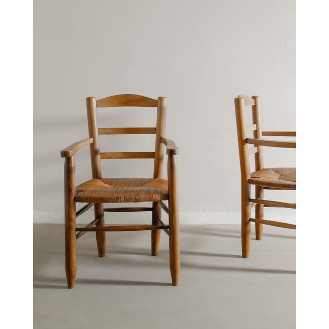 Rare pair of french mid century wooden armchairs attributed to charlotte perriand in stained elm and original straw...