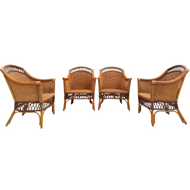 A matched set of four vintage Palecek wicker dining armchairs featuring gracefully rolled arms, arched woven backs, and an...