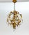 An Italian, gilt metal chandelier in a spherical cage shape. The curling leaves lining the structure dangle octagonal and...