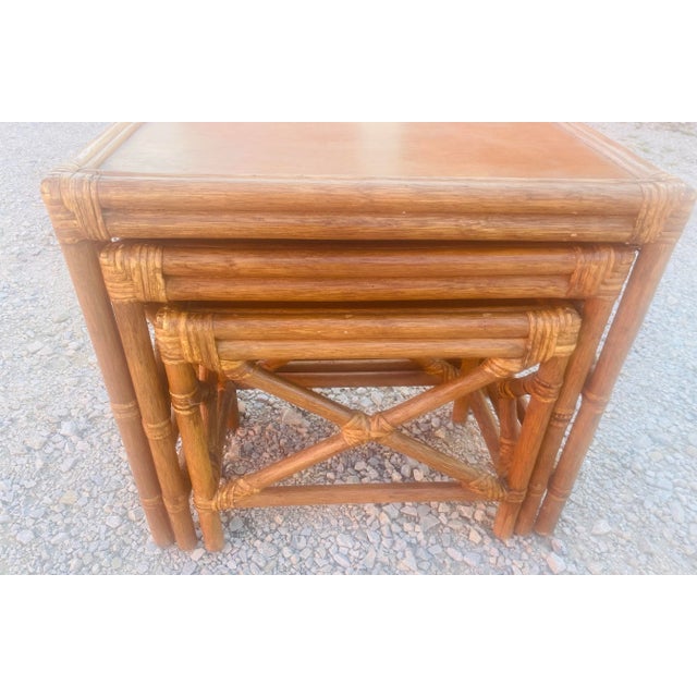 This is a vintage bamboo and walnut nesting tables. There are three tables that graduate under each other with a crossbar...