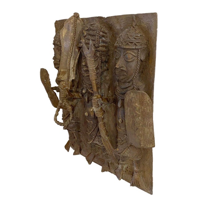 This 14" H African Benin Bronze Plaque features a king warrior and soldiers, created using the lost wax method. Each piece...