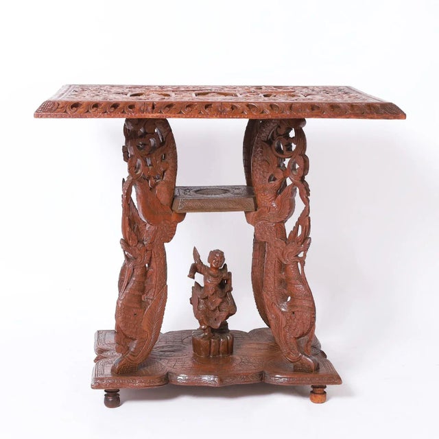 Antique Anglo Indian stand with a dramatic form, crafted in mahogany with an elaborately carved rectangular top depicting...