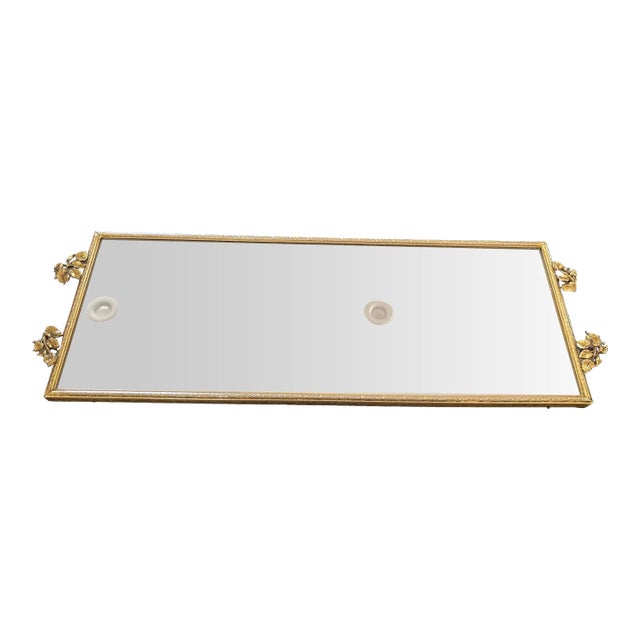 This stunning vanity tray features gilt metal frame richly decorated with a floral pattern. The handles represent a...