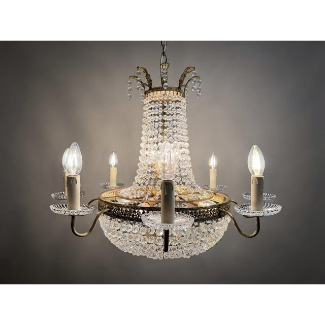 Bring an aura of classic luxury into your home with this exquisite antique French Empire-style chandelier. Defined by a...