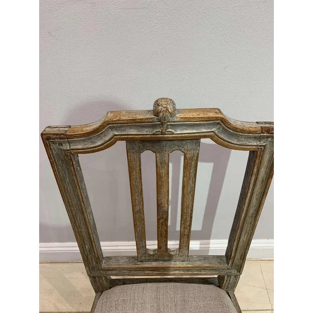 Delightful painted Swedish Gustavian chair from the late C18th century. It has a decorative carved wood flower at the top,...