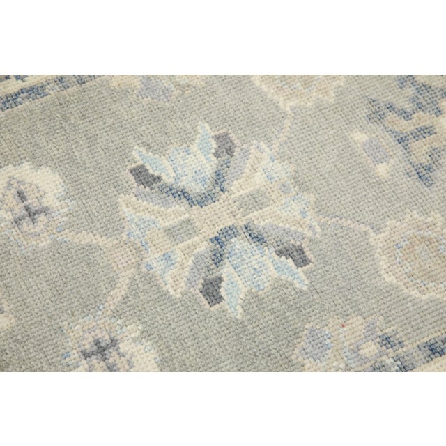 This modern Turkish Oushak rug is a stunning piece of art that has been handwoven using traditional techniques by skilled...