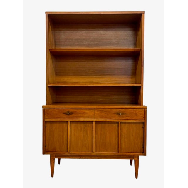 Vintage mid century modern hutch cabinet featuring a clean-lined design with open shelving above and enclosed storage...