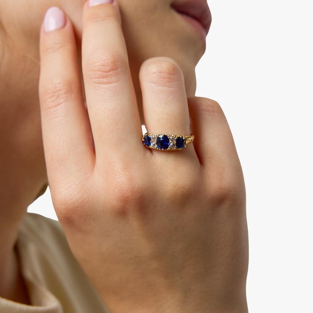 A refined and beautifully balanced Victorian band ring showcasing the rich elegance of natural, untreated sapphires. Three...