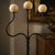 A striking hand-forged wrought iron floor candelabrum dating from the 1990s–2000s, distinguished by its elegant sculptural...