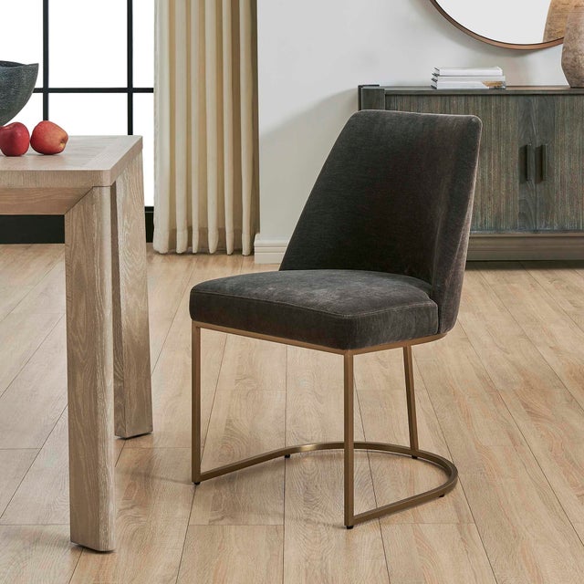 The Hanni Dining Chair Features A Sleek, Curved Steel Frame In A Brass Plated Finish. Upholstered In A Charcoal Polyester...