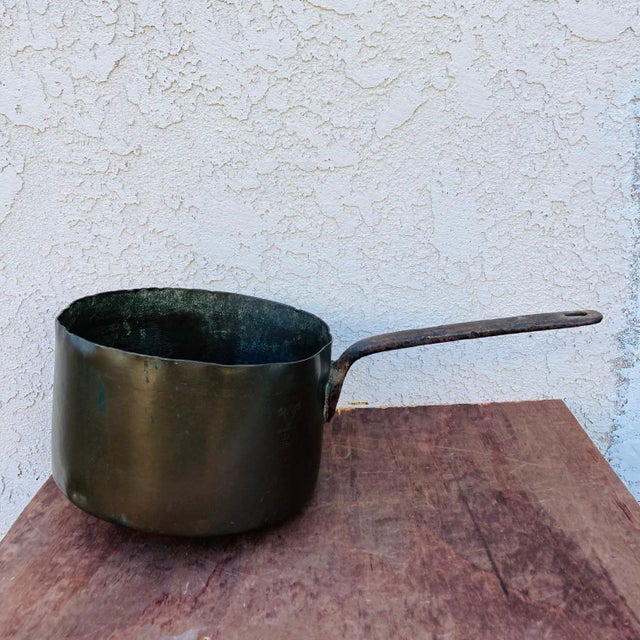 This is a tremendous old antique copper saucepan with riveted iron handle. From the mid 1800s, it is showing its age...