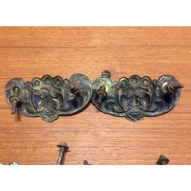 Set of six antique stamped brass bail pulls, four complete and two missing bails,. Pulls feature a striking figural face...