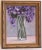 An oil painting of a vase of Lilacs painted in a textured impressionist style on a gray interior background, and framed in...