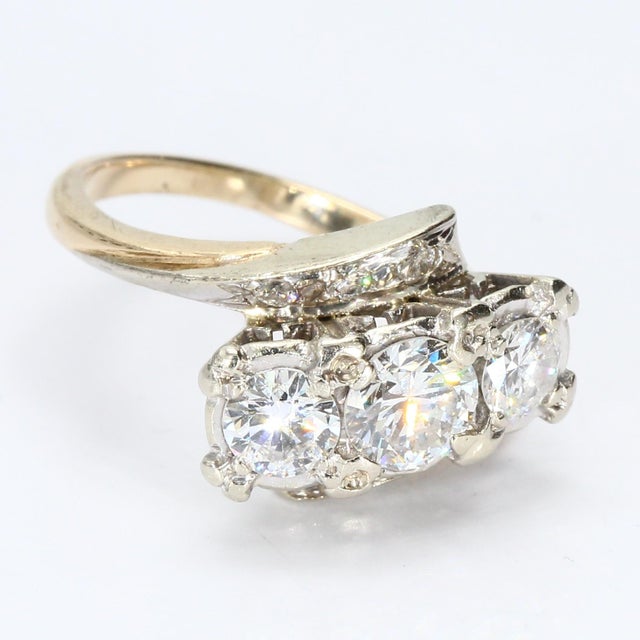 This 14k gold cocktail ring is a striking piece of craftsmanship. Featuring three round white diamonds, the central stone...