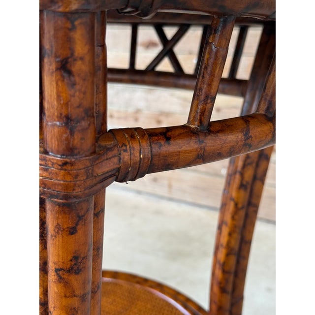 A stylish Late 20th Century rattan center table by PTMC, designed with a warm tortoise finish and woven cane lower and...