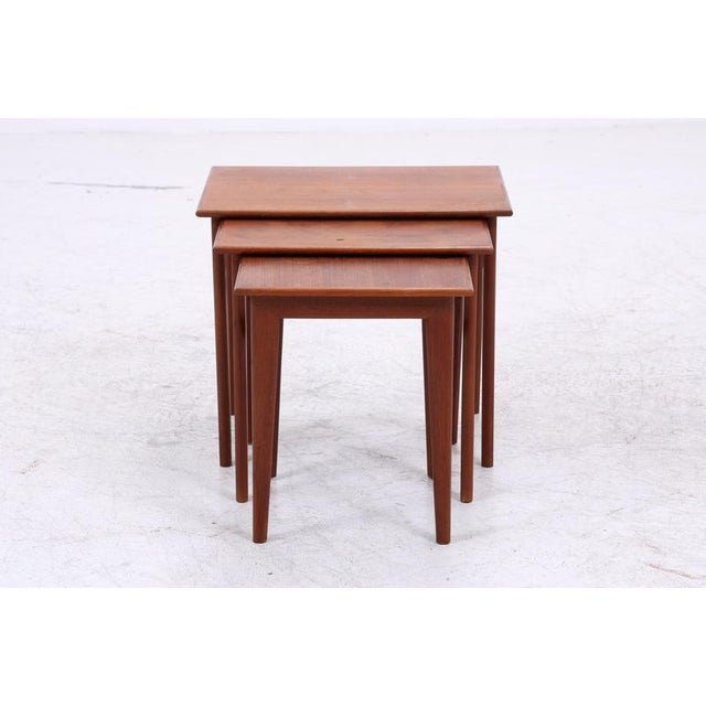 Vintage teak nesting tables with clean lines and a warm wood tone. The three tables, each a different size, can be nested...
