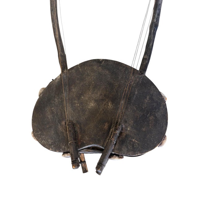 This is a traditional African Bolon or calabash gourd guitar. It is a handcrafted, lute-like stringed instrument typically...