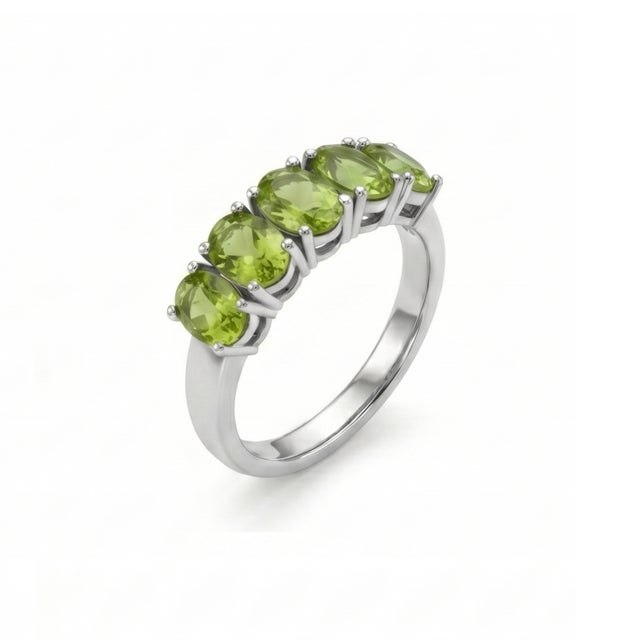 Elegant and refreshing, this beautifully crafted ring showcases a row of vibrant Peridot gemstones, radiating a lively...