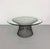A timeless vintage coffee table in the style of Warren Platner, featuring a sculptural steel wire pedestal supporting a...